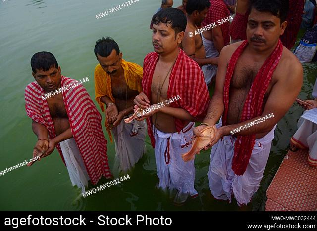 Indian Hindu devotees perform Tarpan, a ritual to pay obeisance to one's forefathers on the last day for offering prayers to ancestors called Pitri Tarpan