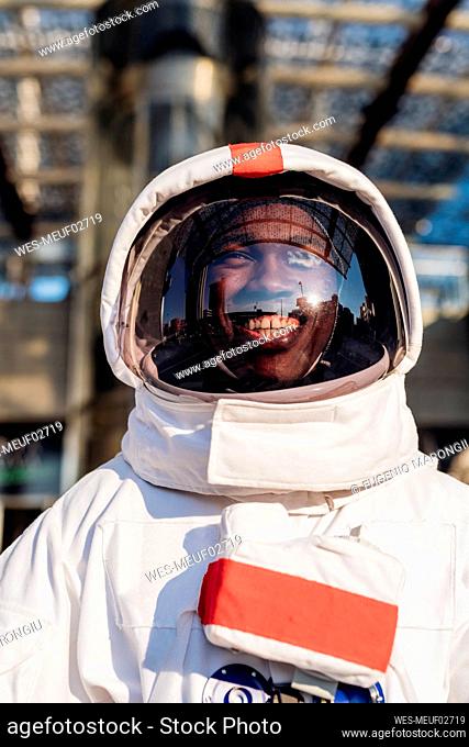 Happy male astronaut with space suit in city