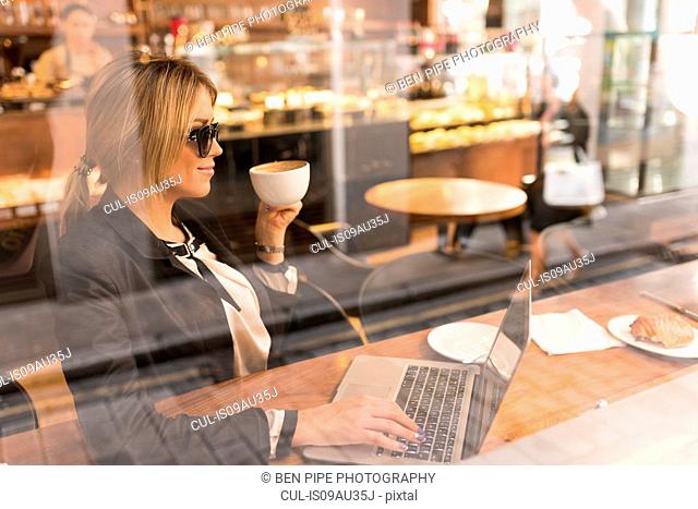 Businesswoman working on laptop in cafe