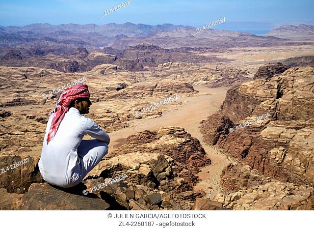 Bedouin and view from the summit of Jebel Umm Adaami (1832m), the highest mountain of Jordan. Jordan, Wadi Rum desert, border with Saudi Arabia