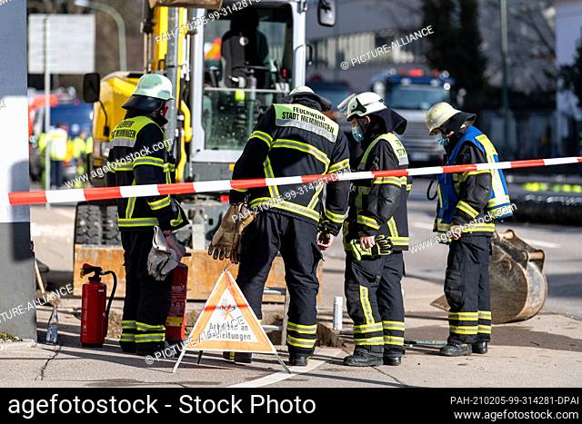 05 February 2021, Bavaria, Memmingen: Firefighters stand behind a sign reading ""Working on gas equipment"" on an open sidewalk in front of a Bavarian Red Cross...