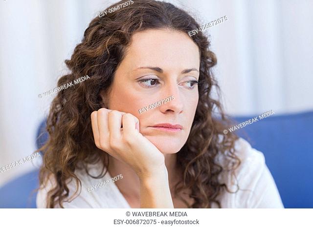 Worried woman sitting on the couch