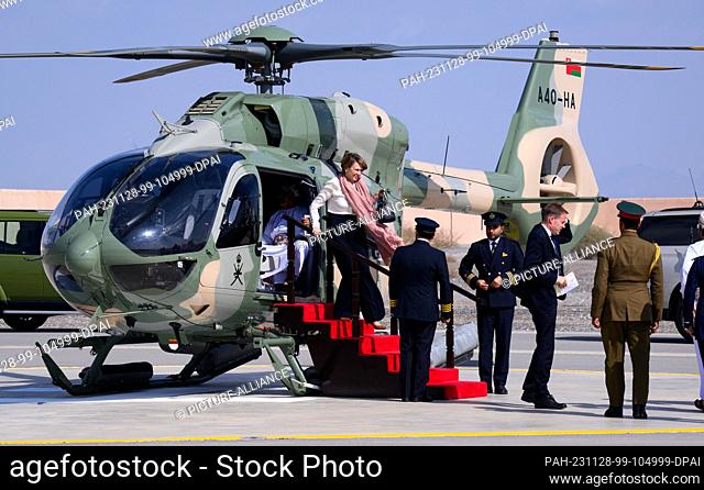 28 November 2023, Oman, Nizwa: Elke Büdenbender (M), wife of Federal President Steinmeier, gets out of an Omani army helicopter that took her from Muscat to...