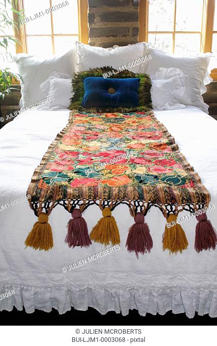 Bed runner and throw pillows on bed