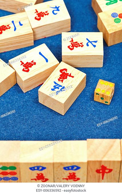 wooden tiles in mahjong game on blue cloth table