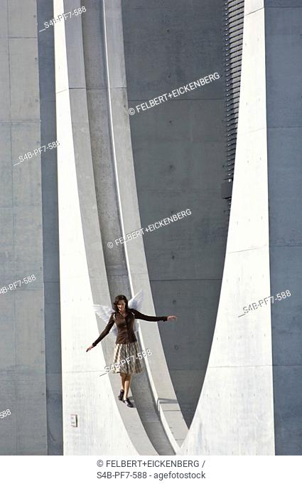 Woman with angel wings balancing, Berlin, Germany