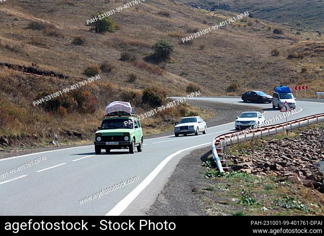 30 September 2023, Armenia, -: Packed cars with belongings of refugees from Nagorno-Karabakh are on their way in the serpentine roads of the South Caucasus