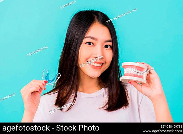 Portrait young Asian beautiful woman smiling holding silicone orthodontic retainers for teeth retaining tools after removable braces