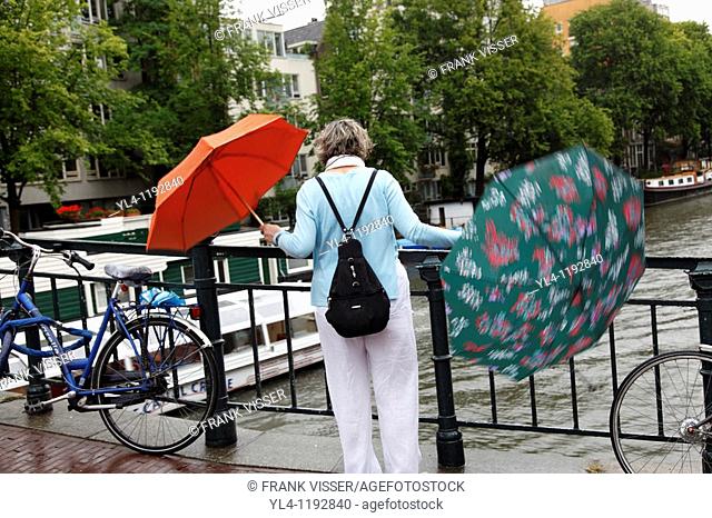Which umbrella will she use, streetscenes of Amsterdam during a rainy day, Netherlands