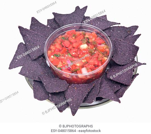 Pico de gallo, authentic mexican salsa in bpa free plastic container and lightly salted organic blue corn tortilla chips isolated on white background