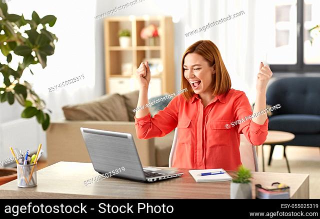 happy woman with laptop working at home office