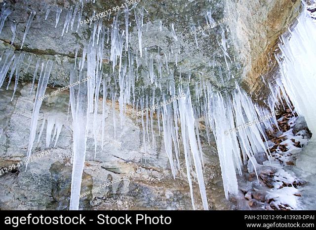 12 February 2021, Bavaria, Haimendorf: Icicles hang from the rock at the Klingenden Waterfall. At this point, the Hüttenbach runs down sandstone steps as a...