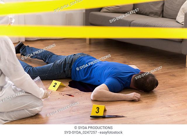 criminalist collecting evidence at crime scene