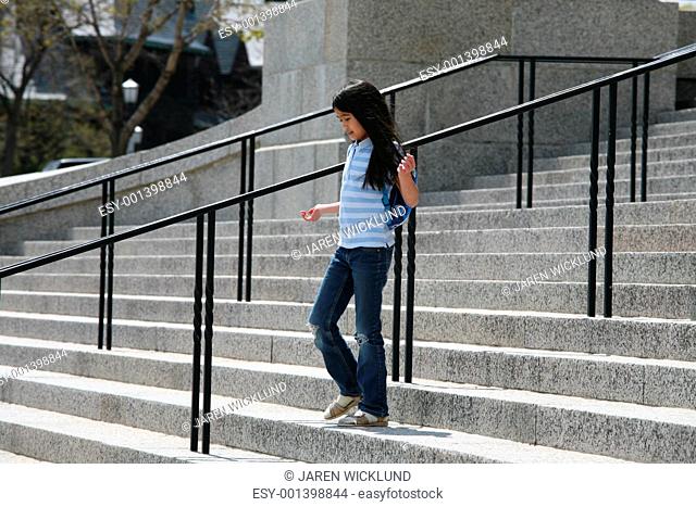 Little girl walking down granite steps