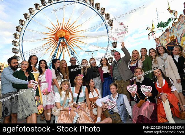 19 September 2022, Bavaria, Munich: Presenter Cathy Hummels (center in dark blue skirt) shows off with her friends in front of the Ferris wheel during her Wiesn...