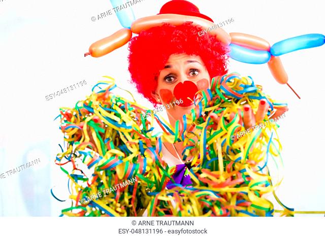Funny clown on party or carnival with paper streamers in her hand