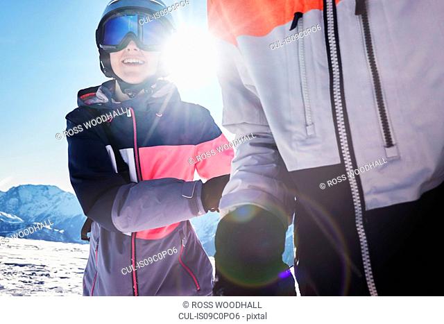 Teenage brother and sister skiers on snow covered mountain top, close up, Alpe-d'Huez, Rhone-Alpes, France