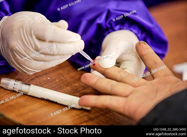 Health worker taking a blood sample from a suspected patient of corona virus during the mass testing in Bandung, West Java, Indonesia