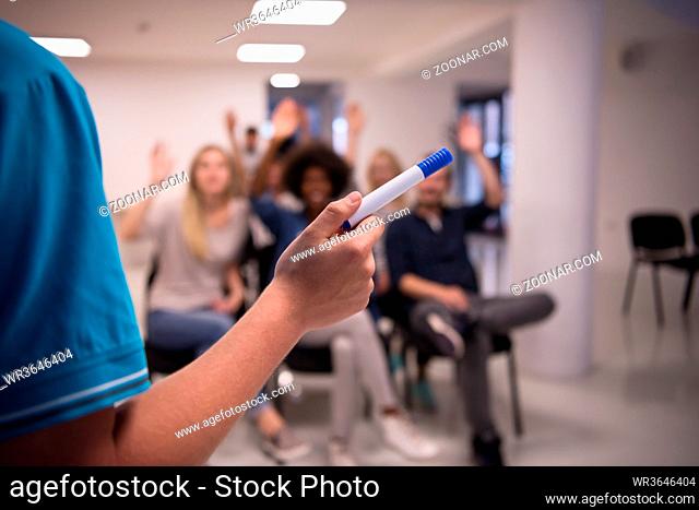 close up of teacher hand with marker while teaching lessons in school classroom to multiethnic students