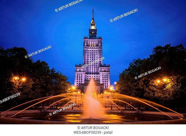 Poland, Warsaw, Palace of Culture and Science at night and fountain in Swietokrzyski Park