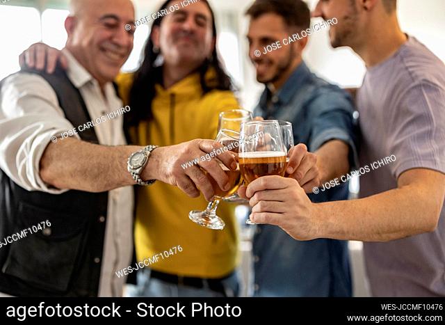 Happy friends toasting beer together