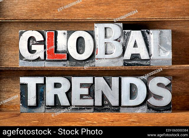 global trends phrase made from metallic letterpress type on wooden tray