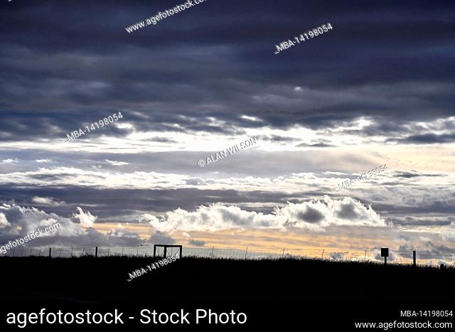 Farm fence silhouette with storm clouds, Overberg, South Africa