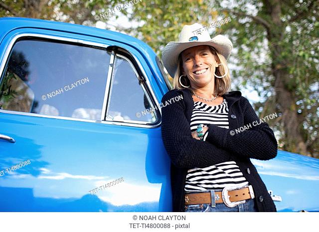 USA, Colorado, Carbondale, Portrait of cowgirl with old fashioned pickup truck
