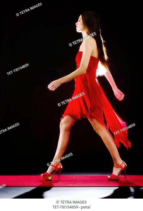 Woman wearing red dress on catwalk