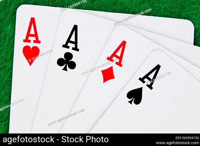 A run of Four aces with green casino table in background winning hand