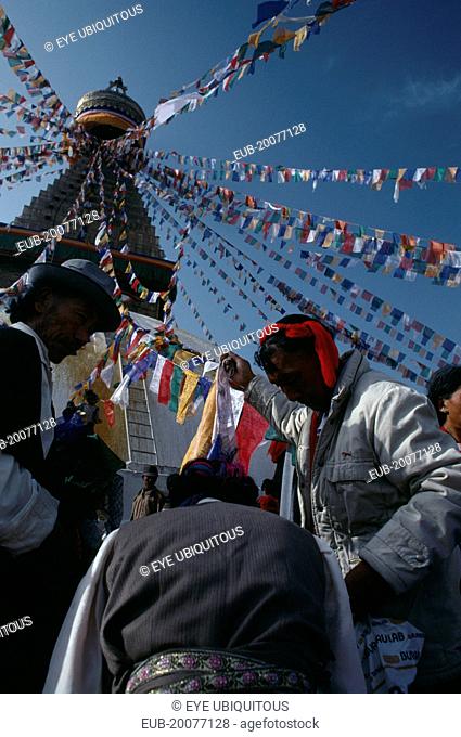 Tibetans hanging stupa with prayer flags during new year celebrations