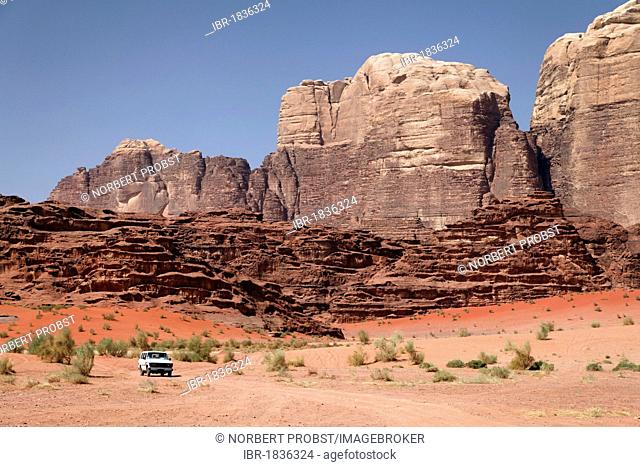 Off-road vehicle in front of mountains, vast plains and red sand in the desert, Wadi Rum, Hashemite Kingdom of Jordan, Middle East, Asia