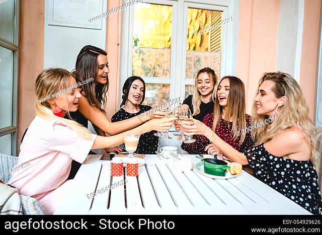 Six girls with glasses of wine at the table