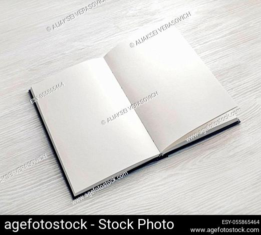 Mockup of opened blank booklet on light wooden background