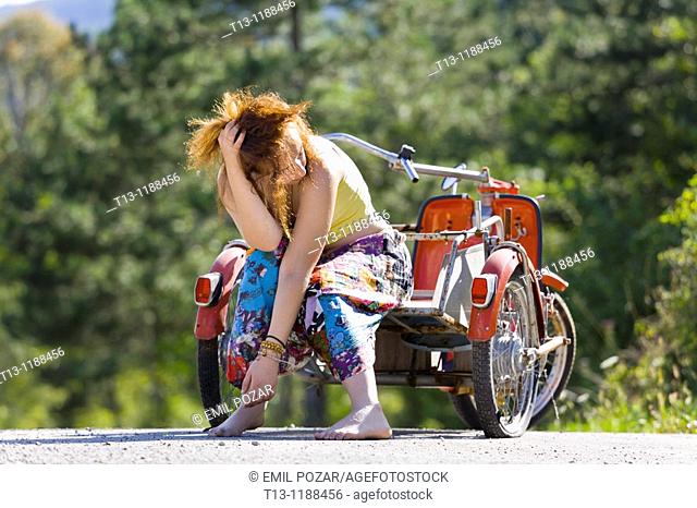 Young woman - troubles with a flat tire