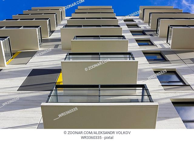 The reverse side of balconies departs to the blue sky. Abstract city mass production background