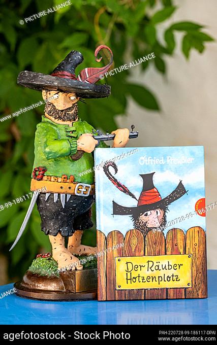 28 July 2022, Bavaria, Regen: The book ""The robber Hotzenplotz"" stands next to a figure of the robber. A pointed hat with a feather