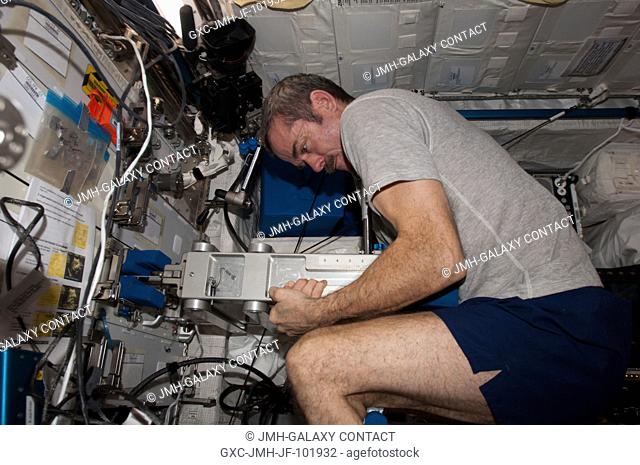 Canadian Space Agency astronaut Chris Hadfield, Expedition 34 flight engineer, uses the Space Linear Acceleration Mass Measurement Device (SLAMMD) in the...