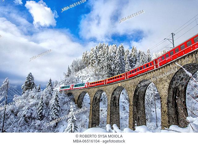 Bernina Express passes through the snowy woods around Filisur Canton of Grisons Switzerland Europe