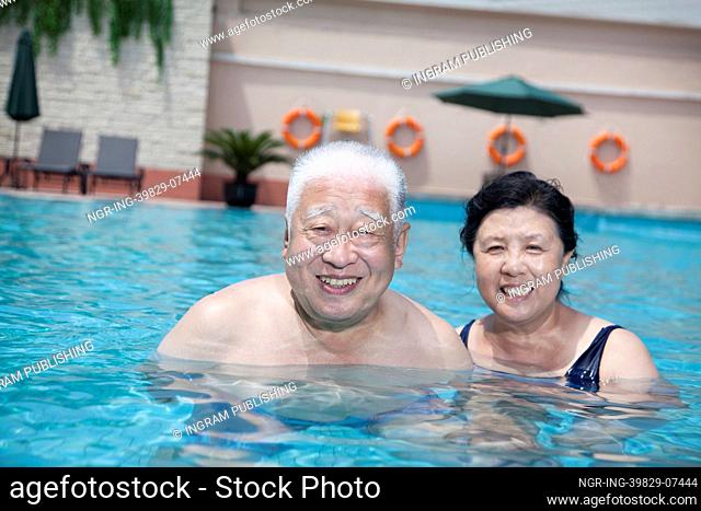 Portrait of senior couple relaxing in the pool