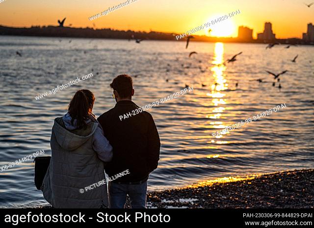 PRODUCTION - 03 March 2023, Iran, Ghom: A young couple stands by Lake Chitgar in the capital Tehran. Many women are currently demonstratively ignoring the...