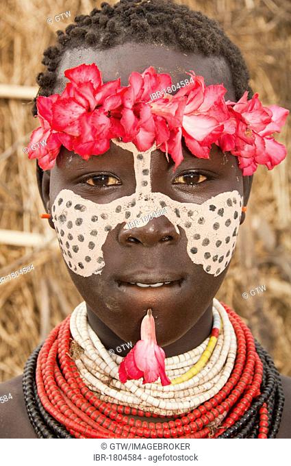 Karo girl with a floral headband, facial paintings, colorful necklaces and lip piercing, portrait, Omo river valley, Southern Ethiopia, Africa