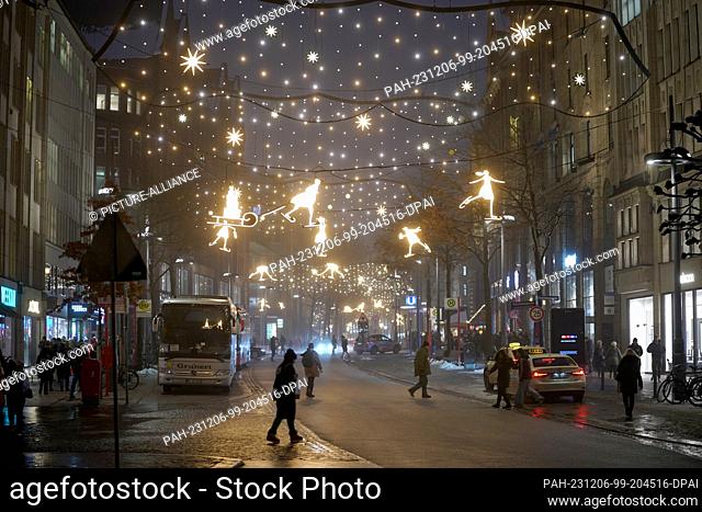 06 December 2023, Hamburg: Passers-by walk through the festively decorated Mönckebergstraße in the city center. Photo: Marcus Brandt/dpa