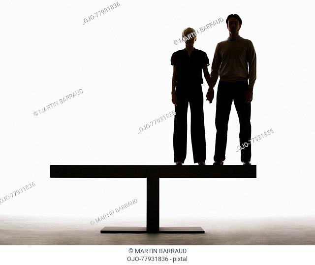 Couple standing on a plank holding hands