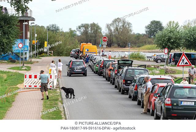 17 August 2018, Germany, Bleckede: Passengers wait with their vehicles at the jetty of the Elbe ferry ""Amt Neuhaus"". The summer drought could bring the water...