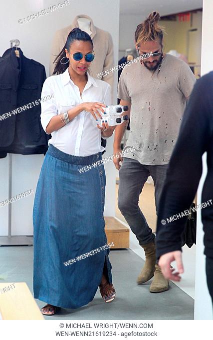 A pregnant Zoe Saldana and husband Marco Perego seen shopping at James Perse and are seen leaving with shopping bags. Zoe is seen carrying 4 bottles of water