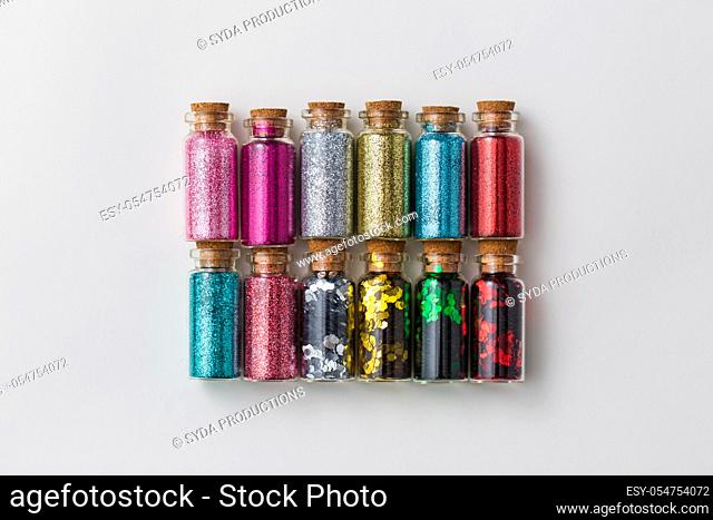 set of glitters in bottles over white background