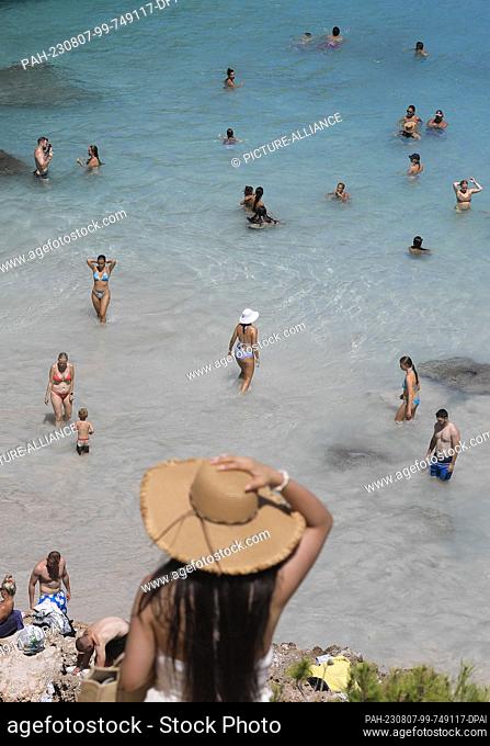 06 August 2023, Spain, Santanyi: People at Calo des Moro beach in Mallorca, one of the most crowded beaches in Mallorca. Photo: Clara Margais/dpa