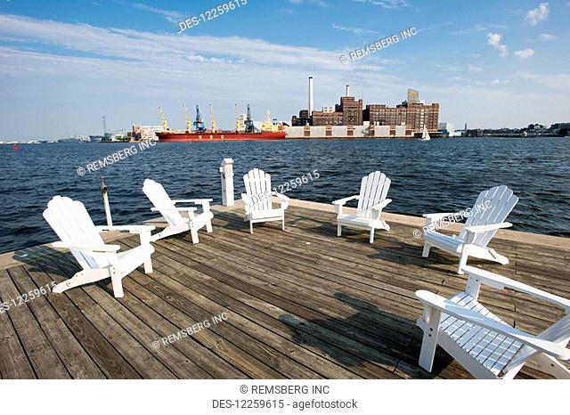 White wooden chairs on a deck by the Baltimore harbour, near Fells Point; Maryland, United States of America