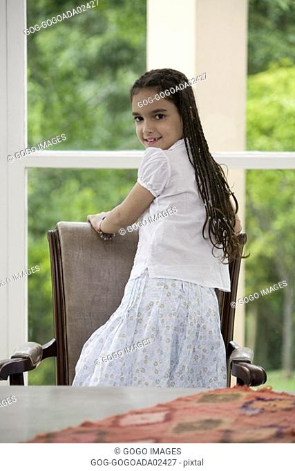 Young girl sitting backwards in chair